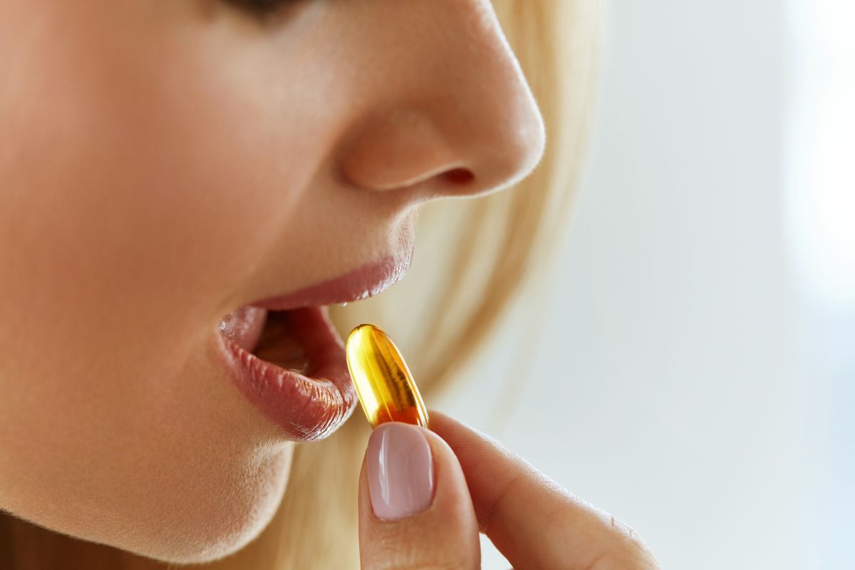 Vitamin,And,Supplement.,Closeup,Of,Beautiful,Young,Woman,Taking,Yellow