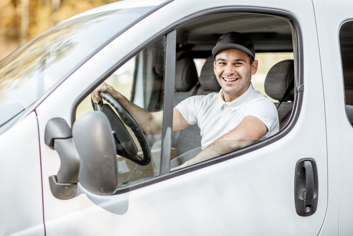 Portrait,Of,A,Cheerful,Delivery,Driver,In,Uniform,Looking,Out