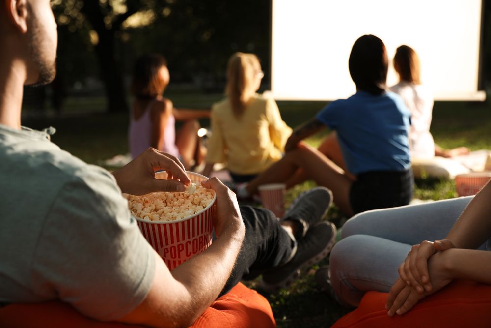 Young,People,With,Popcorn,Watching,Movie,In,Open,Air,Cinema,
