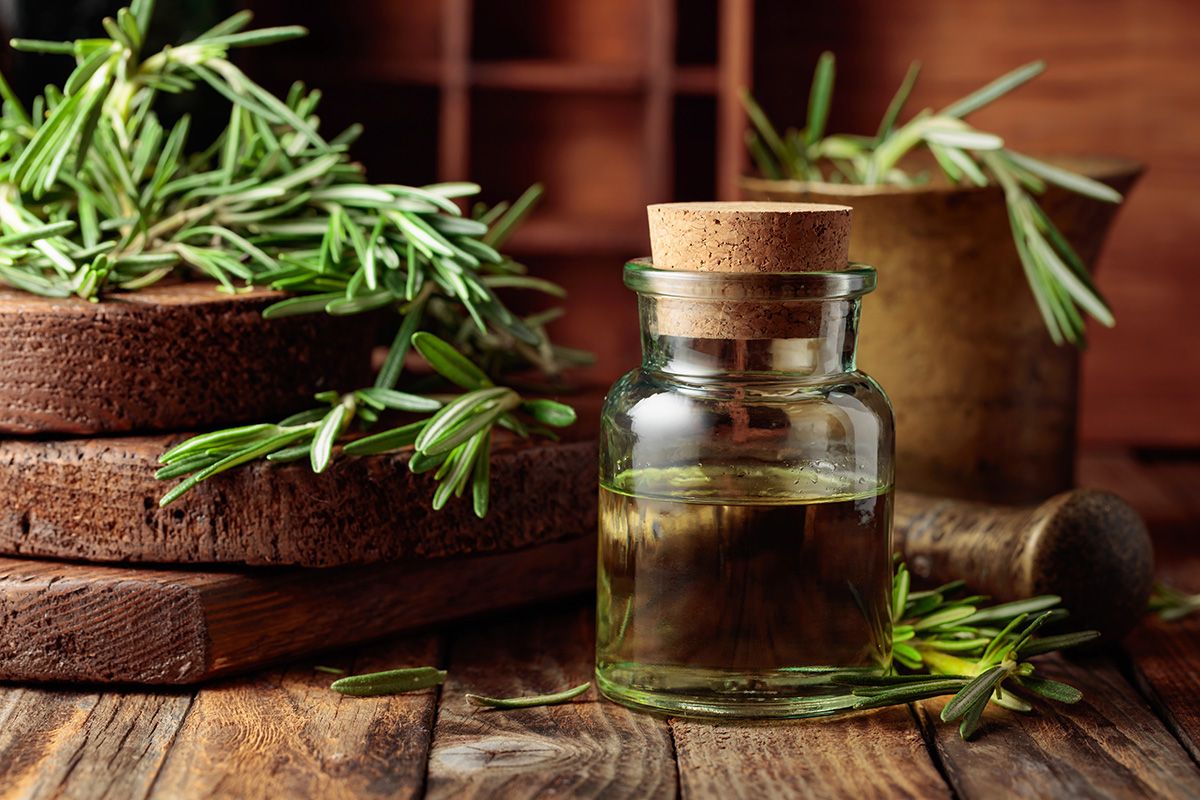 Rosemary,Essential,Oil,Or,Infusion,On,An,Old,Wooden,Table.