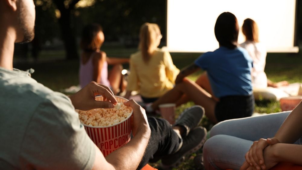 Young,People,With,Popcorn,Watching,Movie,In,Open,Air,Cinema,