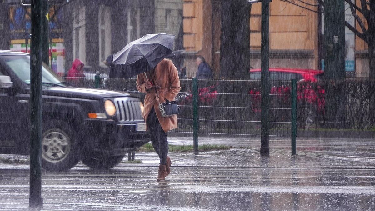 A,Woman,In,A,Brown,Coat,Under,An,Umbrella,Crosses