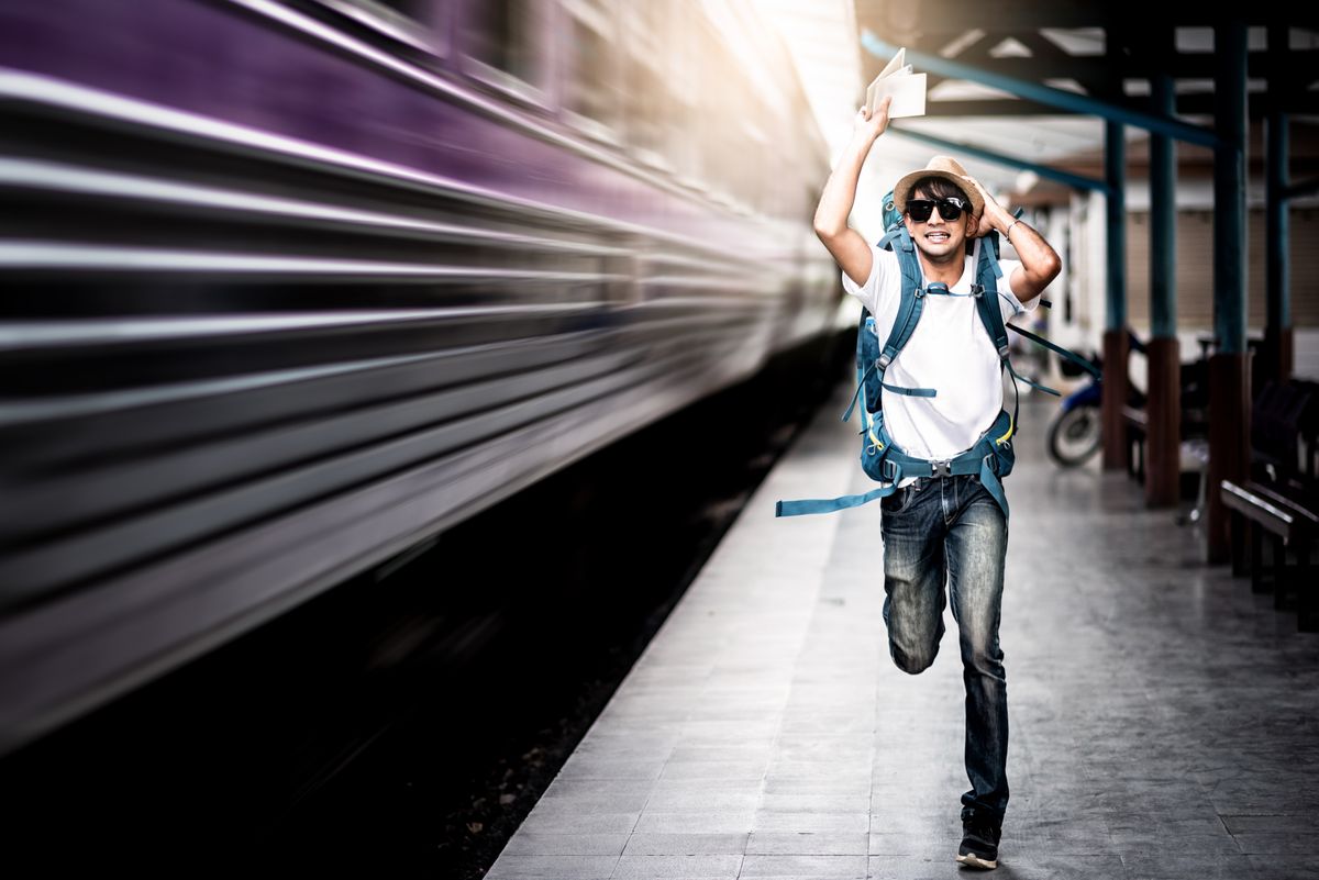 Traveler,Man,Running,After,A,Moving,Train,From,A,Railway