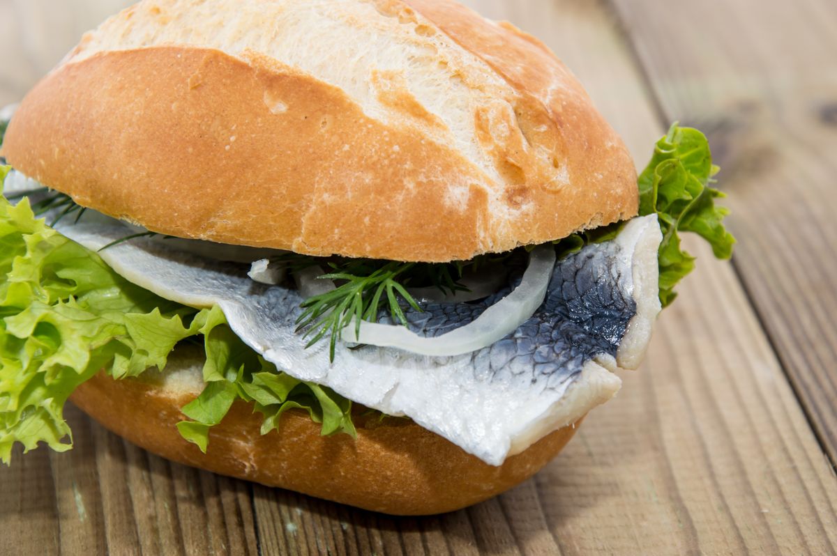 Fresh,Herring,On,A,Roll,Against,Wooden,Background