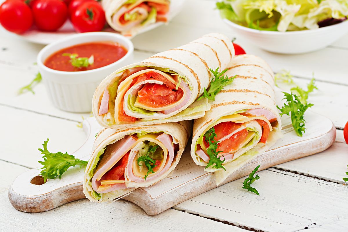 Tortilla,Wrap,With,Ham,,Cheese,And,Tomatoes,On,A,White