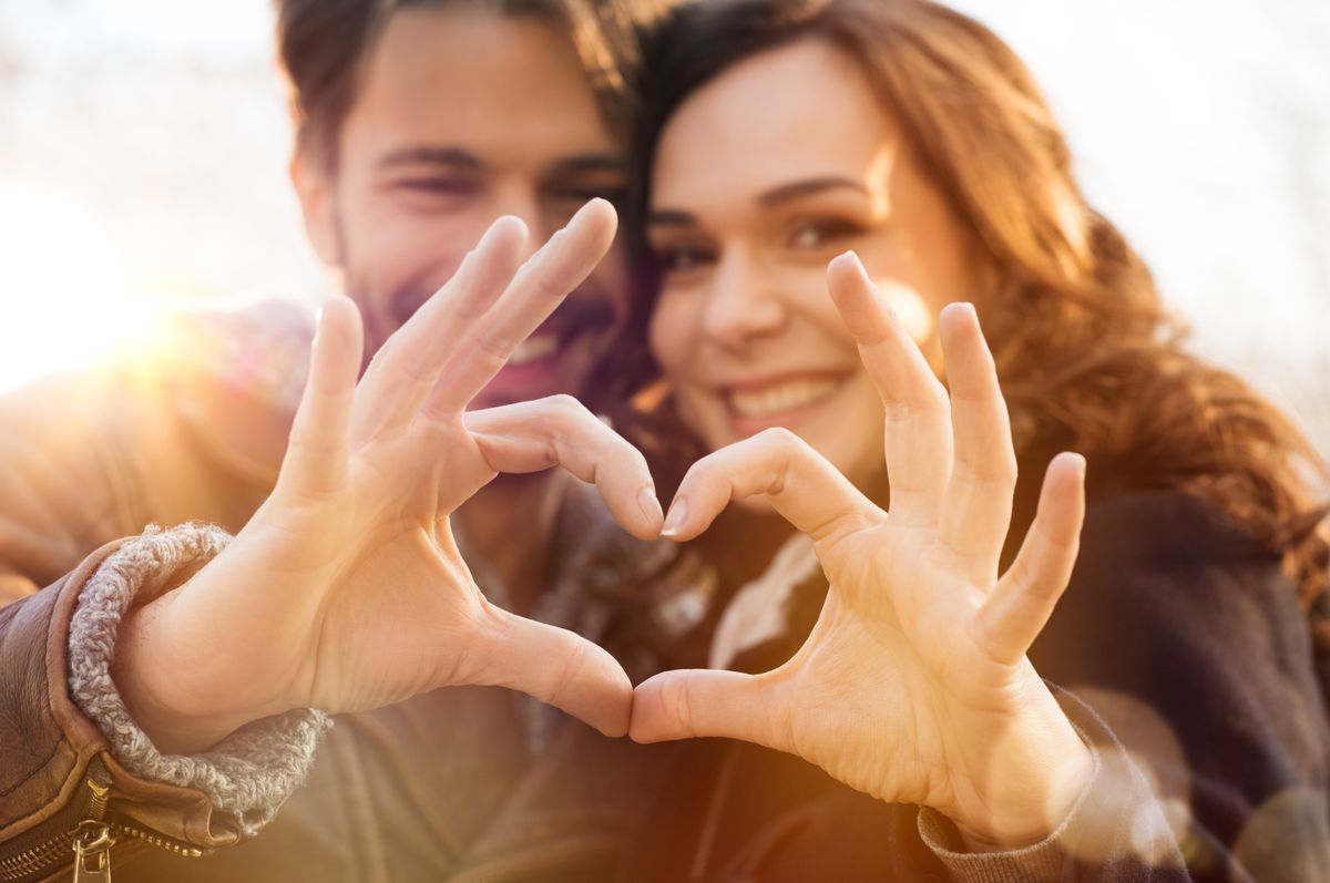 Closeup,Of,Couple,Making,Heart,Shape,With,Hands