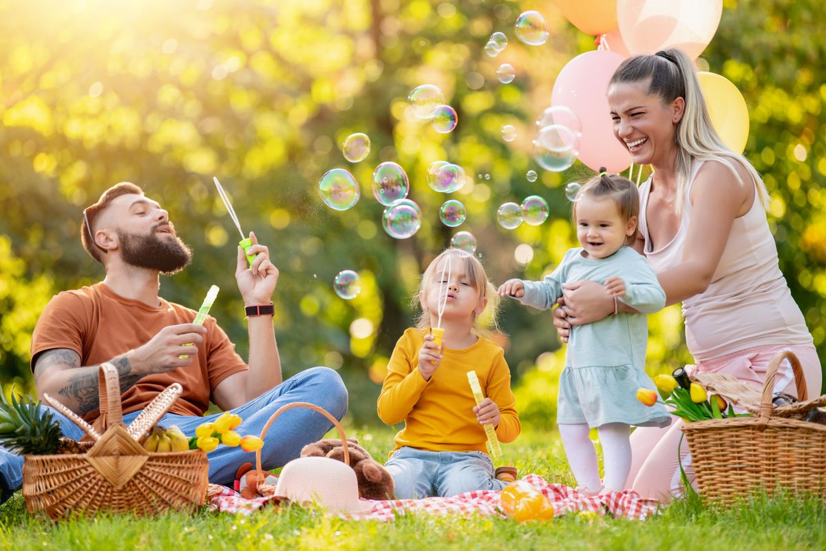 Happy,Family,Resting,In,Summer,Park.cheerful,Family,Picnicking,In,The