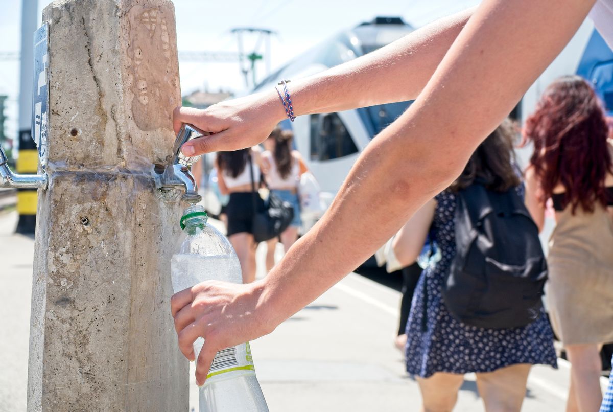 Man,Refilling,His,Water,Bottle,In,The,Summer,Heat,In