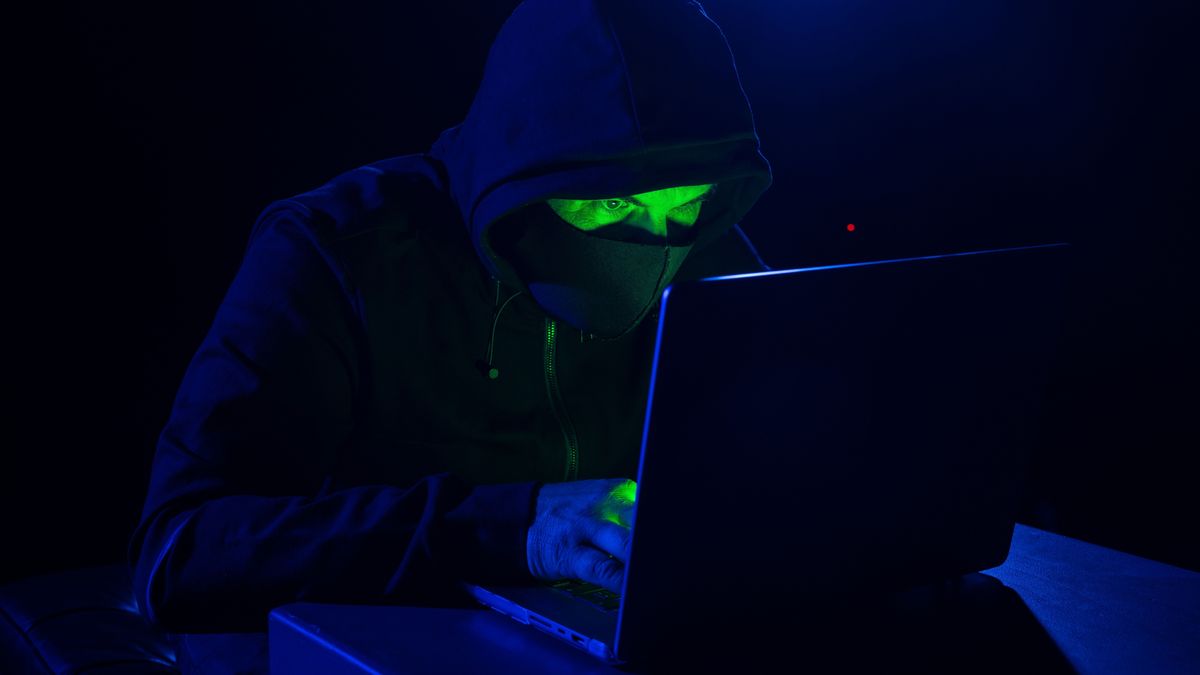 Cyber,Hacker,In,Hood,Behind,Laptop,In,Dark,Room,,Digital