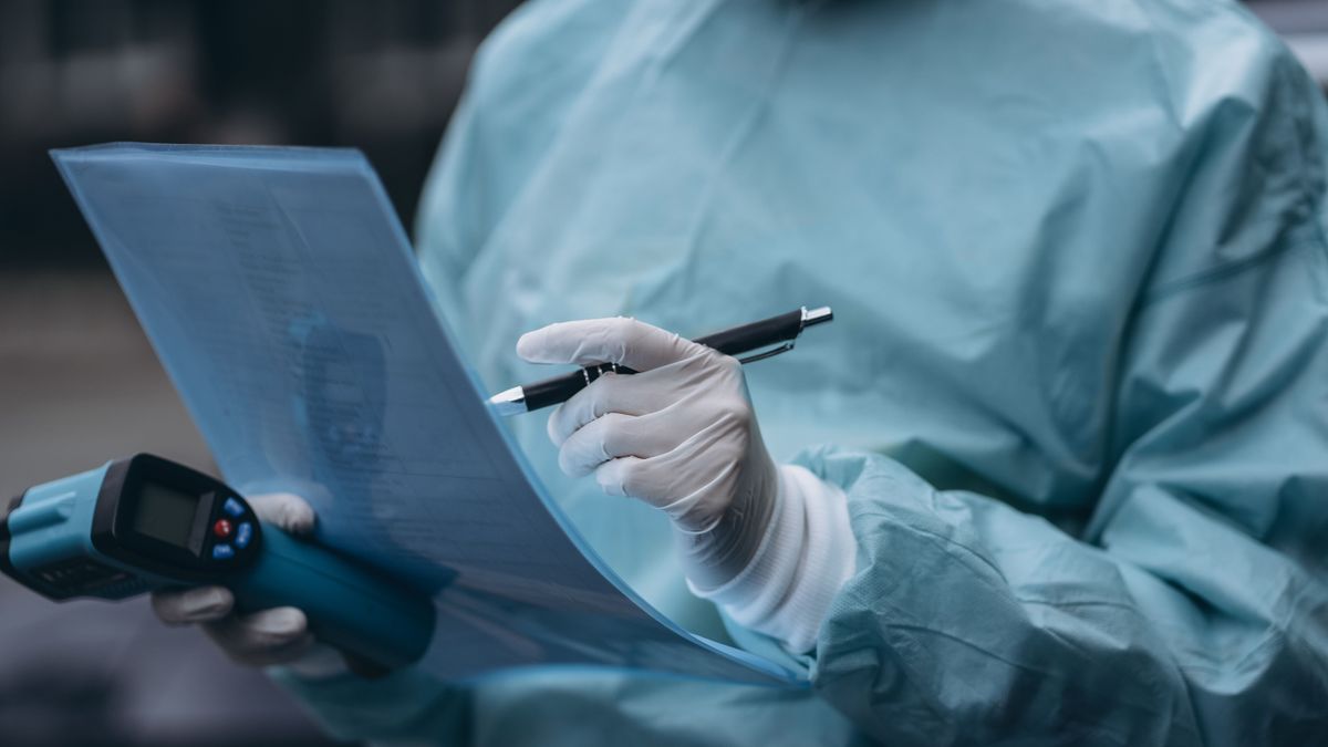 Nurse wears a protective suit and mask during the COVID19 outbreak. rákszűrés
