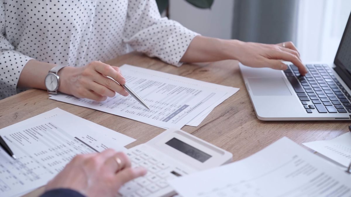 Female,Bookkeeper,Is,Working,On,Finances,Papers,With,A,Colleague,
