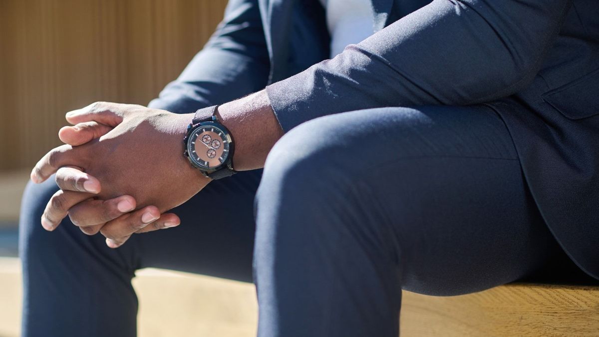 Close up picture of a man in a suit sitting on the bench