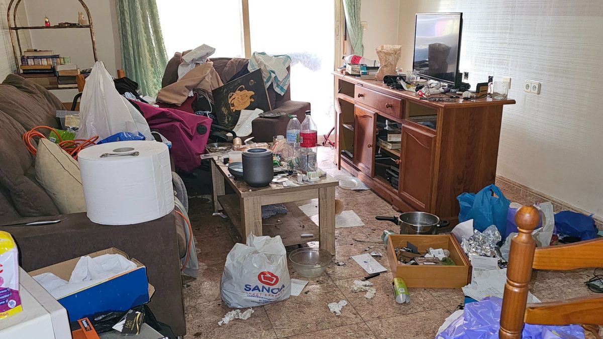 A nappaliban, az asztalon egy urna pihen, a hamvak a földön mindenhol szétszórva pihennek /