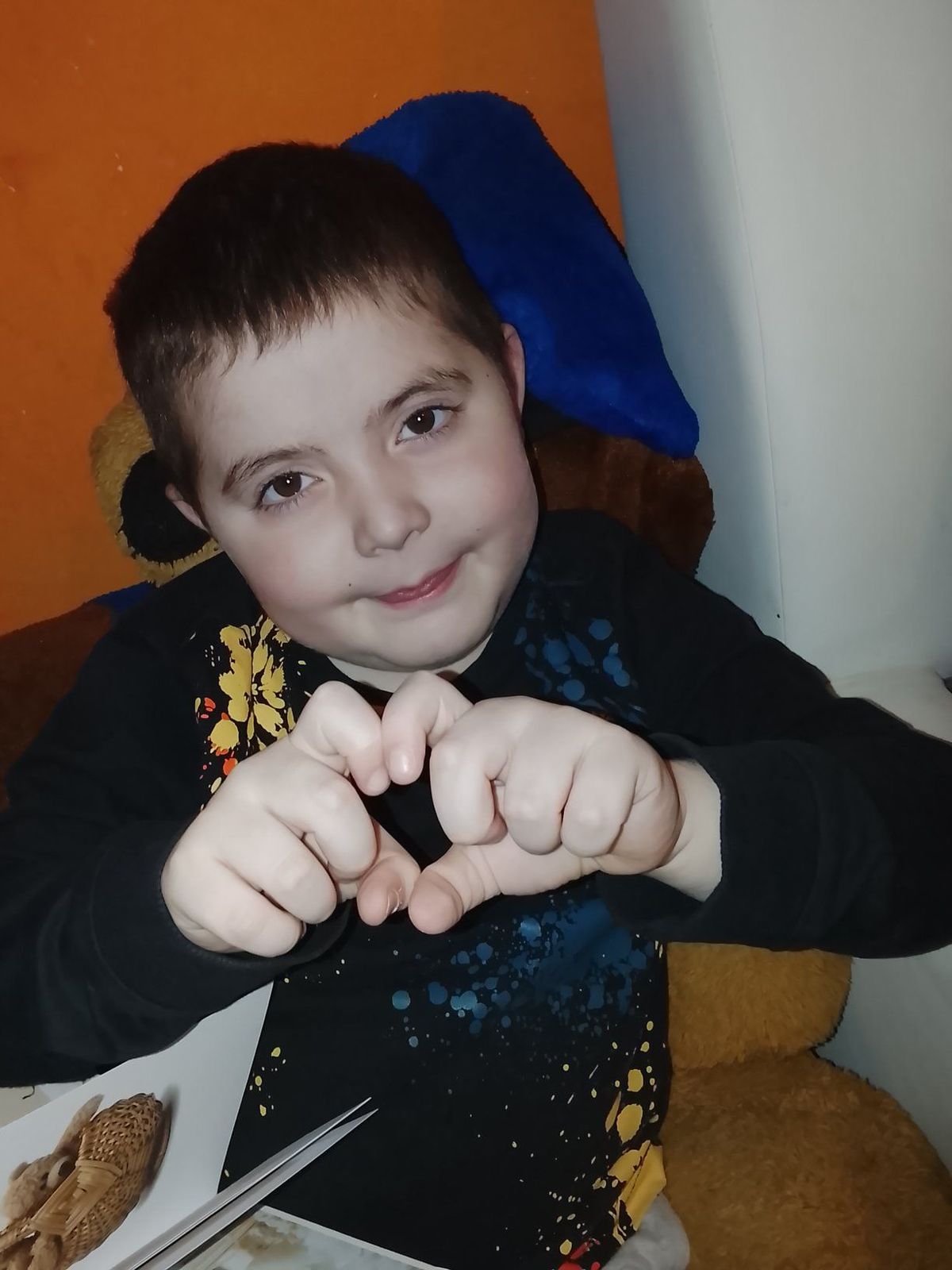 Dényi Tomika szívet formál a kezeivel.