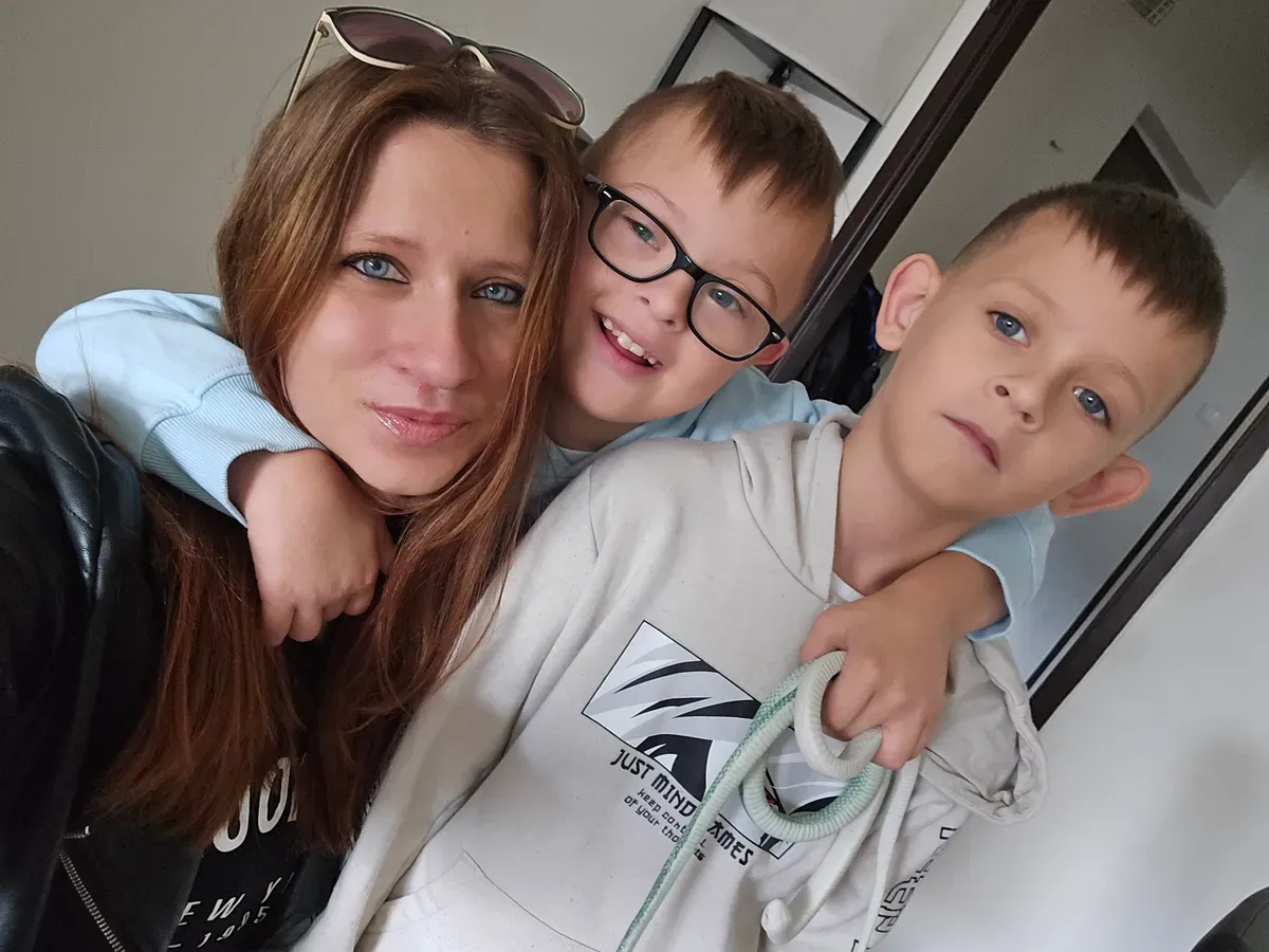 Középen a Down-szindrómás Dominik az anyukája és a testvére mellett