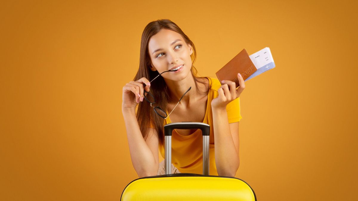 Happy dreamy girl holding passport with tickets