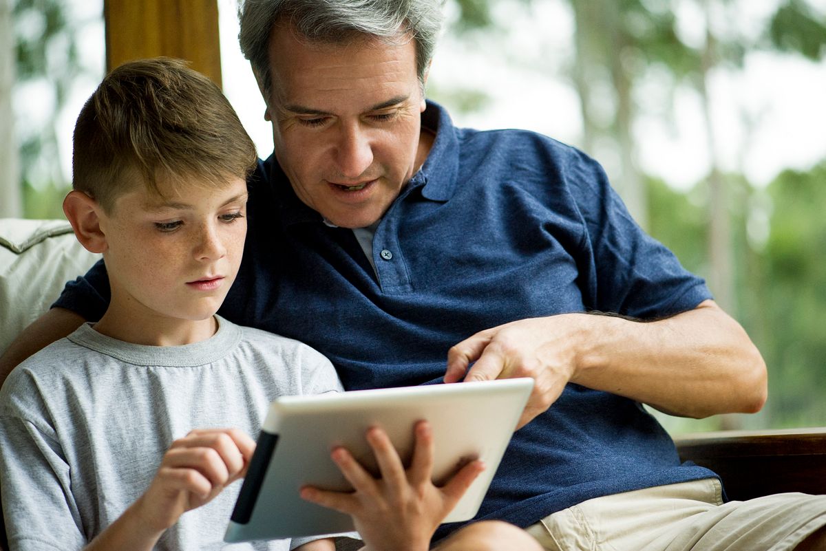 Man with child using digital tablet